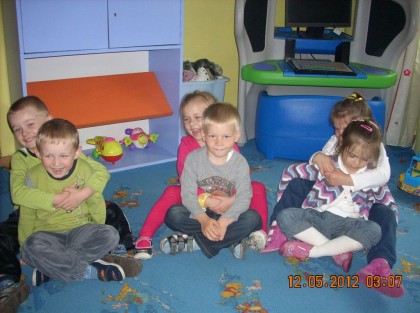 dzieci w przedszkolu siedzą na niebieskim dywanie