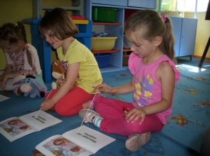 siedzące na dywanie w przedszkolu dzieci