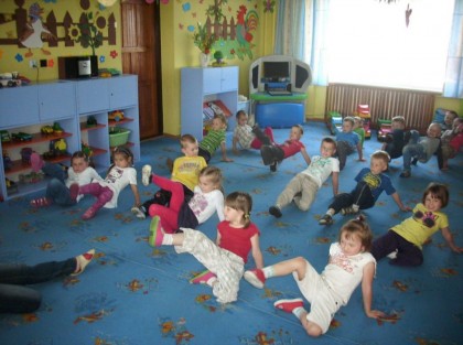 dzieci machające nogami podczas zajęć w przedszkolu