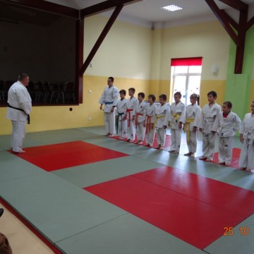 dzieci i ich trener na sali podczas treningu judo